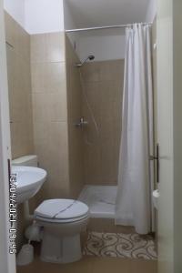 a bathroom with a white toilet and a shower at Hotel Metropol in Mamaia