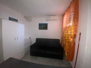 een kamer met een zwarte stoel en een gordijn bij Appartamenti - Spiaggia Zaiana in Peschici