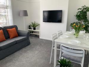 サウサンプトンにある4 Bedroom House By Your Stay Solutions Short Lets & Serviced Accommodation Netley Southampton With Terrace & Gardenのリビングルーム(ソファ、テーブル付)