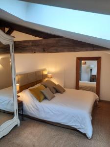 a bedroom with a large white bed with a canopy at Gîte du Petit Moulin in Réaumur