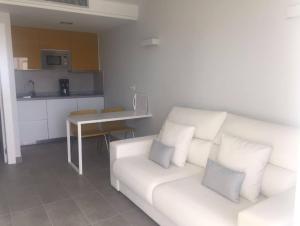 salon z białą kanapą i kuchnią w obiekcie Puerto Príncipe w mieście Puerto Rico de Gran Canaria +8 zdjęć