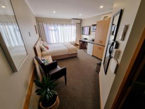 une petite chambre d'hôtel avec un lit et un bureau dans l'établissement Amross Court, à Christchurch