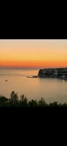 una puesta de sol sobre un cuerpo de agua con un barco dentro en La Stanza Dei Desideri, en Peschici