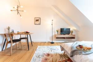a living room with a dining room table and a bed at Design Apartment Zentral & Rooms - Toplage am Opernhaus in Nuremberg