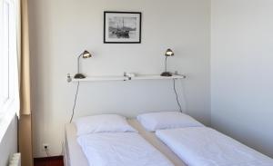 2 camas en una habitación con un estante en la pared en Hótel Dalvík en Dalvík