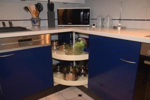 Una cocina con gabinetes azules y un microondas. en Fewo Landweg, en Limburg an der Lahn