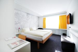 a hotel room with a bed and a desk at Hotel Weiss Kreuz in Thusis