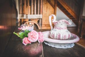 a table with a vase and a plate and flowers at Lavendelhof Die idyllische Landpension in Langenreinsdorf +26 photos