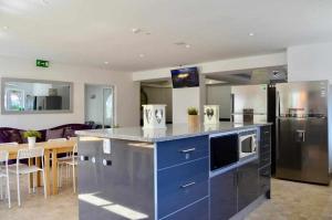 eine Küche mit einer blauen Insel mit Arbeitsplatte in der Unterkunft Villa w Private Pool, Tennis Courts & Golf Putt in Vilamoura