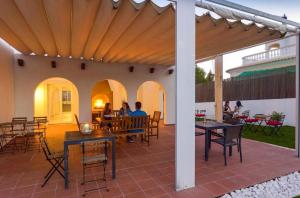 eine Terrasse mit Tischen und Stühlen und Menschen, die an den Tischen sitzen in der Unterkunft Villa w Private Pool, Tennis Courts & Golf Putt in Vilamoura