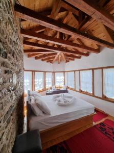 um quarto com uma cama grande e uma parede de pedra em The Heart of the Bazaar Guest house em Gjirokastër