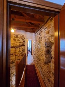 um corredor de uma casa com uma parede de pedra em The Heart of the Bazaar Guest house em Gjirokastër