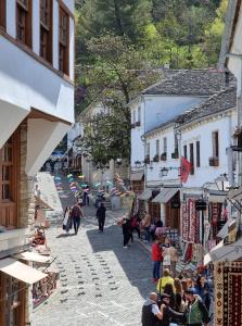 um grupo de pessoas andando por uma rua em uma cidade em The Heart of the Bazaar Guest house em Gjirokastër