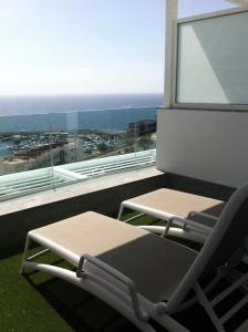 einen Stuhl und einen Tisch auf einem Balkon mit Aussicht in der Unterkunft Puerto Príncipe in Puerto Rico de Gran Canaria