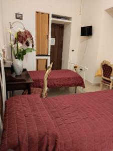 sypialnia z 2 łóżkami i stołem z czerwonym kocem w obiekcie Little Anema & Core w mieście Castellammare di Stabia