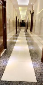 a hallway with a white floor in a building at Mithilesh Hotel in Kaithal