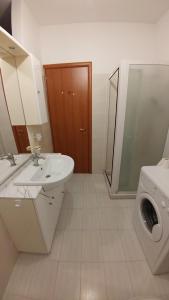 un bagno con lavandino e lavatrice di Appartamento Tra Mare E Lago a Foce Varano