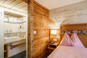 a bedroom with a bed and a sink and a mirror at Alpenblick Hotel & Restaurant Wilderswil by Interlaken in Wilderswil +59 photos