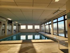 - une grande piscine dans un bâtiment doté de fenêtres dans l'établissement Studio 105 op zeedijk met frontaal zeezicht 1ste verdiep, à Middelkerke