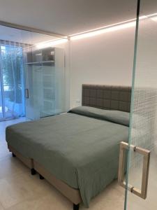 a bedroom with a bed and a glass wall at Velar Apartment Suites in Lignano Sabbiadoro