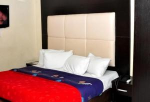 een bed met witte kussens en een rode deken bij Room in Lodge - Eaglespark1960 Hotel in Ikeja