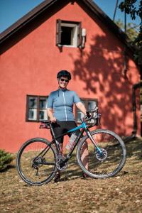 mężczyzna stojący obok roweru przed budynkiem w obiekcie Rusty's Cottage w mieście Sedlčany