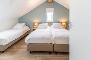 Duas camas num pequeno quarto com paredes azuis em Boutique Resort Schaardijk vakantieappartement em Scharendijke