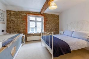 a bedroom with a bed and a window at The Shoe Box cottage with allocated parking in Malmesbury