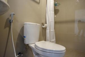 a bathroom with a white toilet and a shower at RedDoorz Plus near Solo Baru in Solo +49 photos