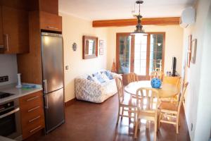 eine Küche und ein Esszimmer mit einem Tisch und Stühlen in der Unterkunft Homenfun Menorca Playa de Fornells I in Fornells