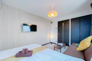 a bedroom with a bed and a couch and a television at japan house sky tree in Tokyo