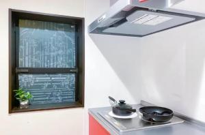 una cocina con una ventana con 2 sartenes en una estufa en japan house sky tree, en Tokio