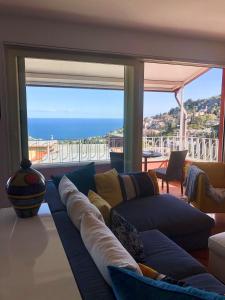 タオルミーナにあるTaonasi Taormina Apartmentsのリビングルーム(ソファ付)が備わり、海の景色を望めます。