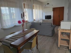 a living room with a table and a couch at Le Logge Apartment in Baratti