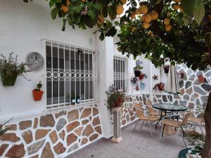 a patio with a table and chairs and a stone wall at Calle Dr Fleming 3 bedroom home in San Javier