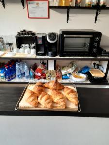 eine Theke mit einem Tablett mit Croissants und Brot in der Unterkunft B&B Confine in Como