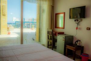a bedroom with a bed and a tv and a window at Diamond Dahab House in Dahab