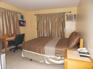 una camera d'albergo con letto, scrivania e computer di Room in Lodge - Mikagn Hotels and Suites a Ibadan