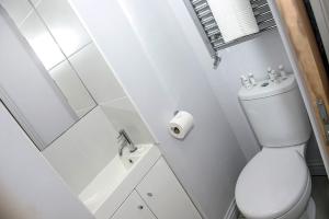 a white bathroom with a toilet and a sink at Book A Base - Chester - City Road in Chester