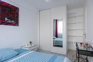Schlafzimmer mit einem Spiegel, einem Schreibtisch und einem Bett in der Unterkunft Appartement lumineux, et chaleureux in Savigny-sur-Orge