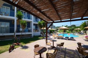 a patio with chairs and tables and a swimming pool at Sevastos Studios in Faliraki