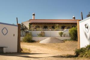 a house with a white wall and stairs in front of it at Aproveite o sabor do Alentejo in Vila Verde de Ficalho