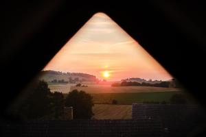 d'une fenêtre offrant une vue sur la pyramide et le coucher du soleil. dans l'établissement Rusty's Cottage, à Sedlčany