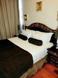 a bedroom with a large bed with white sheets and pillows at Owu Crown Hotel - Regular in Ibadan