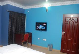 um quarto com paredes azuis e uma cama e uma porta em Room in Lodge - Owees Place-okota em Lagos