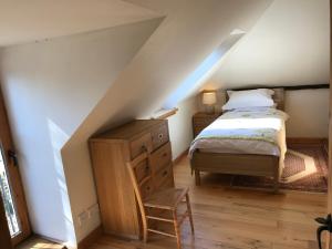 a bedroom with a bed and a chair in a attic at The Coach House at Riverlea in Blairgowrie