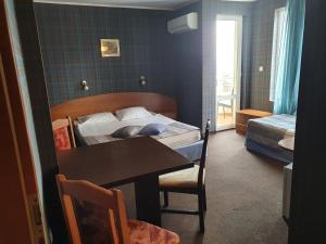 Family Hotel Lazuren Briag في مدينة بورغاس: غرفة نوم بسرير وطاولة وغرفة بسرير