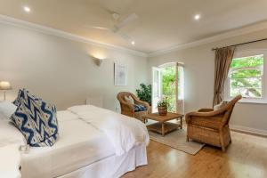 赫曼努斯Auberge Burgundy Boutique Hotel & Spa的一间卧室，有一张床、两把椅子和一扇窗户