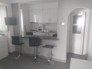 a kitchen with a counter and two bar stools at Buarcos-Figueira de Foz in Figueira da Foz