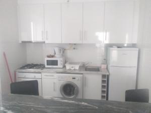 a kitchen with a washing machine and a refrigerator at Buarcos-Figueira de Foz in Figueira da Foz